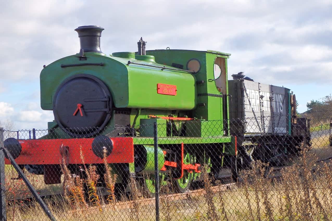 A green train engine resting in sidings, at the Big Pit National Coal Museum, Wales.